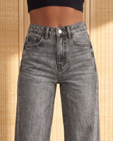 Close-up of the gray Langley Wide Leg Jeans showing the high-rise waistband, shank button, zip fly and five-pocket styling with the acid-wash denim texture