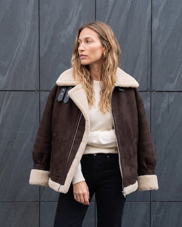 Model wearing the dark brown Leni Suede Vintage Coat over a cream top and black jeans, front view