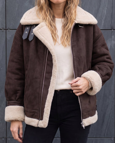 Close-up of the Leni coat's cream faux shearling collar, buckle strap and asymmetric zip in dark brown