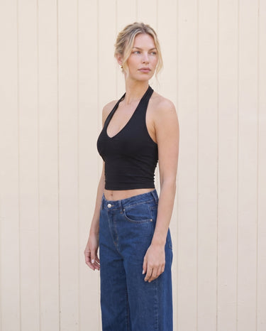 Model in the black halter crop cami and wide-leg jeans, angled front view – Moriel Heritage
