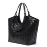 The Lucca Woven Tote in black, studio hero view showing the flared shopper silhouette and gold-tone handle keepers