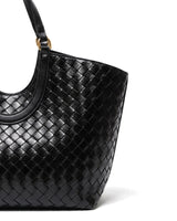 Close-up of the Lucca Woven Tote's glossy basketweave texture and handle attachment in black