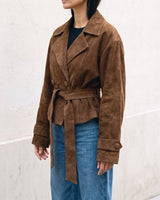 Three-quarter side view of the dark brown Margot Tie-waist Coat over blue jeans