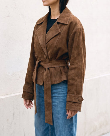 Three-quarter side view of the dark brown Margot Tie-waist Coat over blue jeans