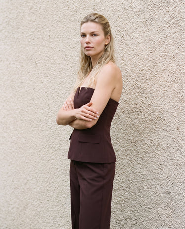Model with arms crossed wearing the brown structured strapless top, three-quarter view – Moriel Heritage