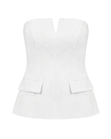 White structured strapless top with notched V front and flap pockets, flat lay – Moriel Heritage