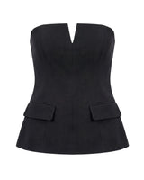 Black structured strapless top with notched V front and flap pockets, flat lay – Moriel Heritage