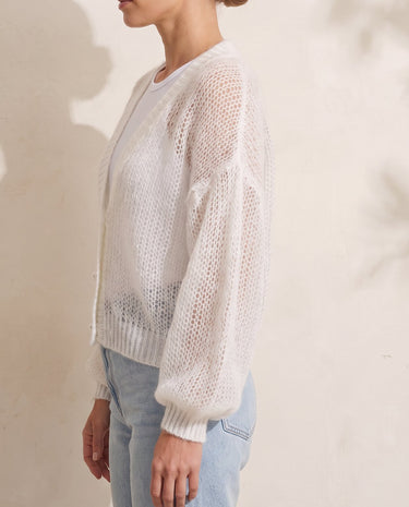 Marisol Knit Cardigan in white — side profile on model showing the sheer open-knit drape