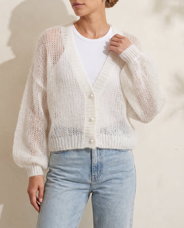 Marisol Knit Cardigan in white — three-quarter front view on model, hand at the collar