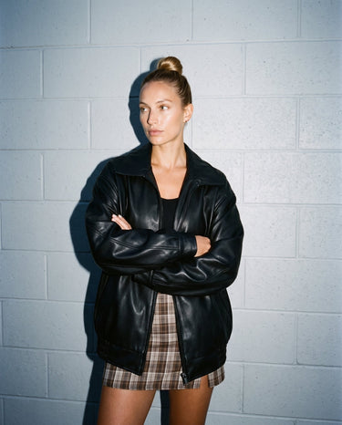 Model with arms crossed in the oversized black Marseille Faux Leather Jacket, front view