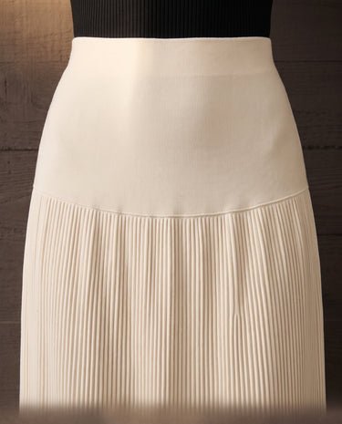 Close-up of the ivory Matilde Skirt showing the wide smooth waistband, seamed hip yoke and the point where the fine pleating begins