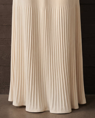Detail of the ivory Matilde Skirt's fine vertical pleating and the soft flare at the floor-length hem