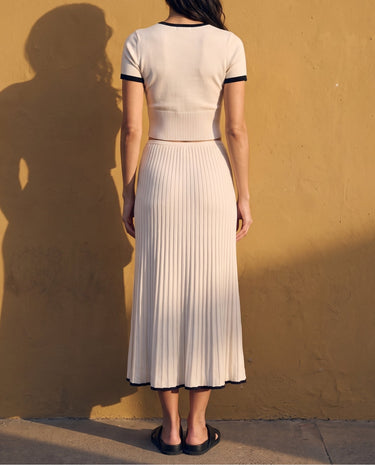 Mireva Knit Set in cream white — back view on model showing the pleated knit skirt