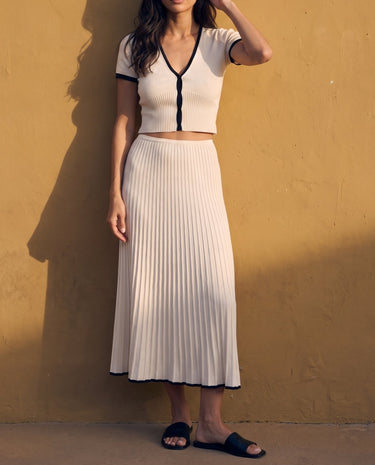 Mireva Knit Set in cream white — side view showing the ribbed pleats and black hem trim