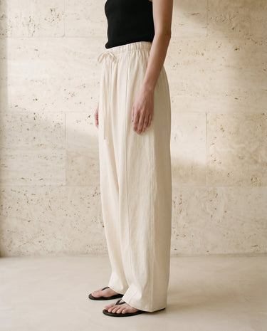 Cream wide-fit pants on model, waist-down front view – Moriel Heritage