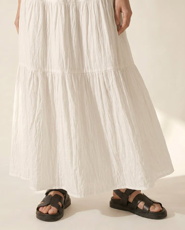 The Noemi A-Line Skirt in white — tiered maxi skirt, front view on model