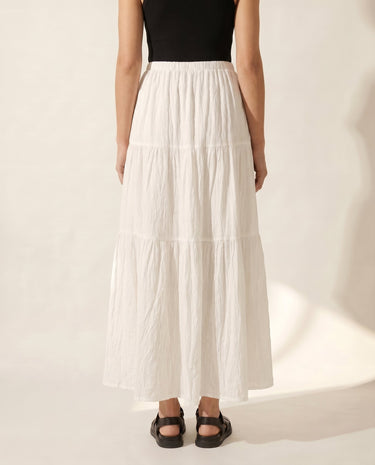 The Noemi A-Line Skirt in white — tiered maxi skirt, back view on model