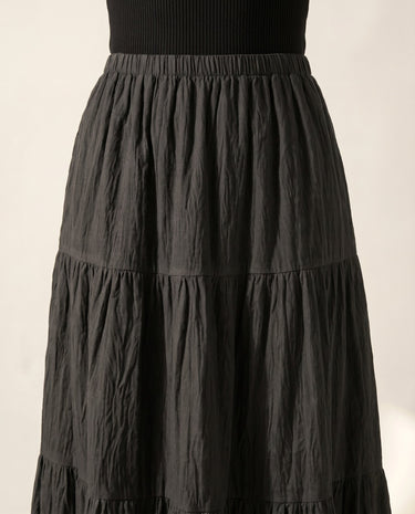 The Noemi A-Line Skirt in black — close-up of elastic waist and tiered panels