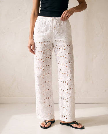 Noire Embroidered Straight Leg Pants in white — eyelet embroidered trousers, front view on model