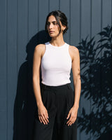 Full-length view of the white ribbed cotton tank styled with black trousers – Moriel Heritage