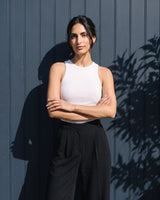 Model with arms crossed wearing the white ribbed cotton tank – Moriel Heritage