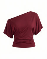 Odile Tee in burgundy — asymmetric off-shoulder draped knit top with dolman sleeves, flat-lay