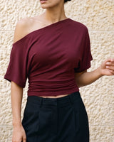 Odile Tee in burgundy — front view on model, styled with black tailored trousers