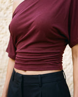 Odile Tee in burgundy — cropped front view showing the ruched waist and cropped hem