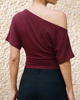 Odile Tee in burgundy — back view on model showing the draped asymmetric neckline