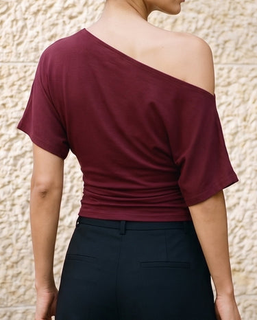 Odile Tee in burgundy — back view on model showing the draped asymmetric neckline