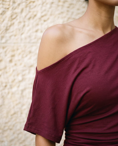 Odile Tee in burgundy — close-up of the off-shoulder neckline and soft drape