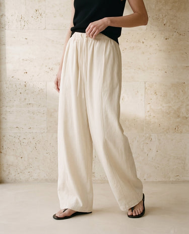 Cream wide-fit pants styled with black top on model – Moriel Heritage
