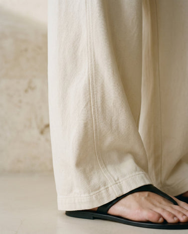 Cream wide-fit pants, flowing hem close-up with sandal – Moriel Heritage