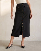 Side view of the black Elegant Retro Slimming Skirt in movement, showing the front hem slit opening as the model walks