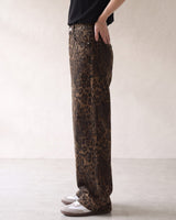 Rhea Leopard Print Jeans — side view on model showing the loose straight leg and hand in pocket