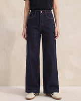 Model wearing dark denim Rhys Jeans with a black tee and trainers, full front view – Moriel Heritage
