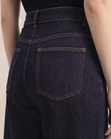 Close-up of dark denim jeans showing back patch pocket with embroidered motif – Moriel Heritage