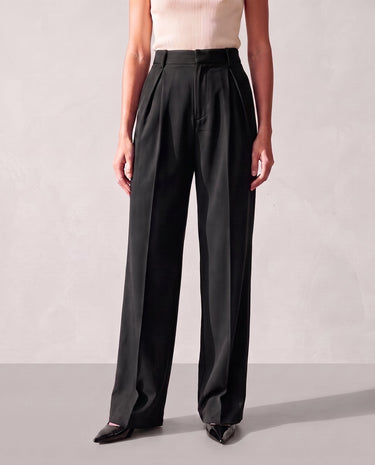 Model wearing the black Riviera Tailored Pants, front view showing the high waist, front pleats and wide straight leg