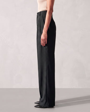 Side view of the black Riviera Tailored Pants showing the clean side seam and the wide leg falling to the floor