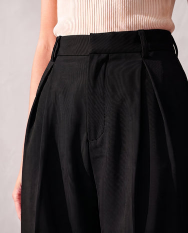 Close-up of the front of the black Riviera Tailored Pants showing the high waistband, belt loops, double front pleats and side pocket