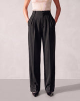 Front view of the black Riviera Tailored Pants with the model's hands in the side pockets, showing the tailored drape