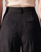 Close-up of the back of the black Riviera Tailored Pants showing the waistband, belt loops and welt pocket detail