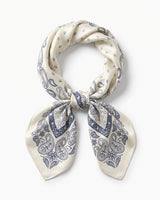 Satin Scarf in navy paisley — ivory silky scarf with navy paisley border print, tied in a knot, flat lay on white