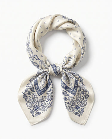 Satin Scarf in navy paisley — ivory silky scarf with navy paisley border print, tied in a knot, flat lay on white