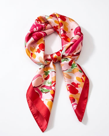 Satin Scarf in pink abstract floral — pink, red and coral print with red border, tied, flat lay on white