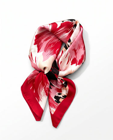 Satin Scarf in red brushstroke — painterly red and pink floral print with red border, tied, flat lay on white