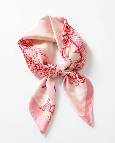 Satin Scarf in rose folk floral — pink silky scarf with red floral print, tied in a knot, flat lay on white
