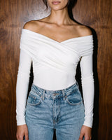 Model wearing white off-shoulder bodysuit with blue jeans, cropped front view – Moriel Heritage