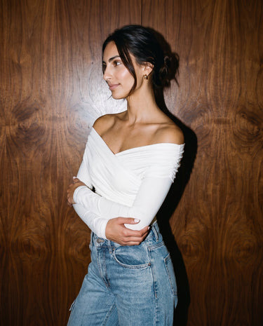 Model wearing white off-shoulder bodysuit, side view – Moriel Heritage