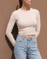 Model wearing beige long-sleeve crew-neck top with blue jeans, cropped front view – Moriel Heritage